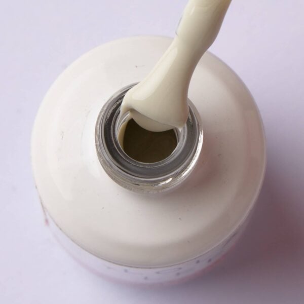 Brush lifting creamy milky beige gel polish from the bottle